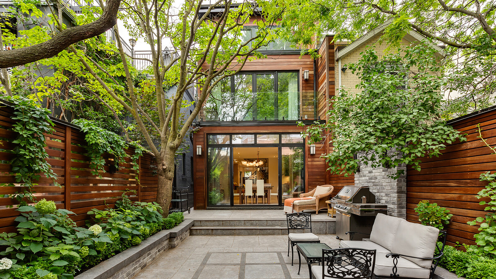 Rear glass box addition opening onto a lush courtyard