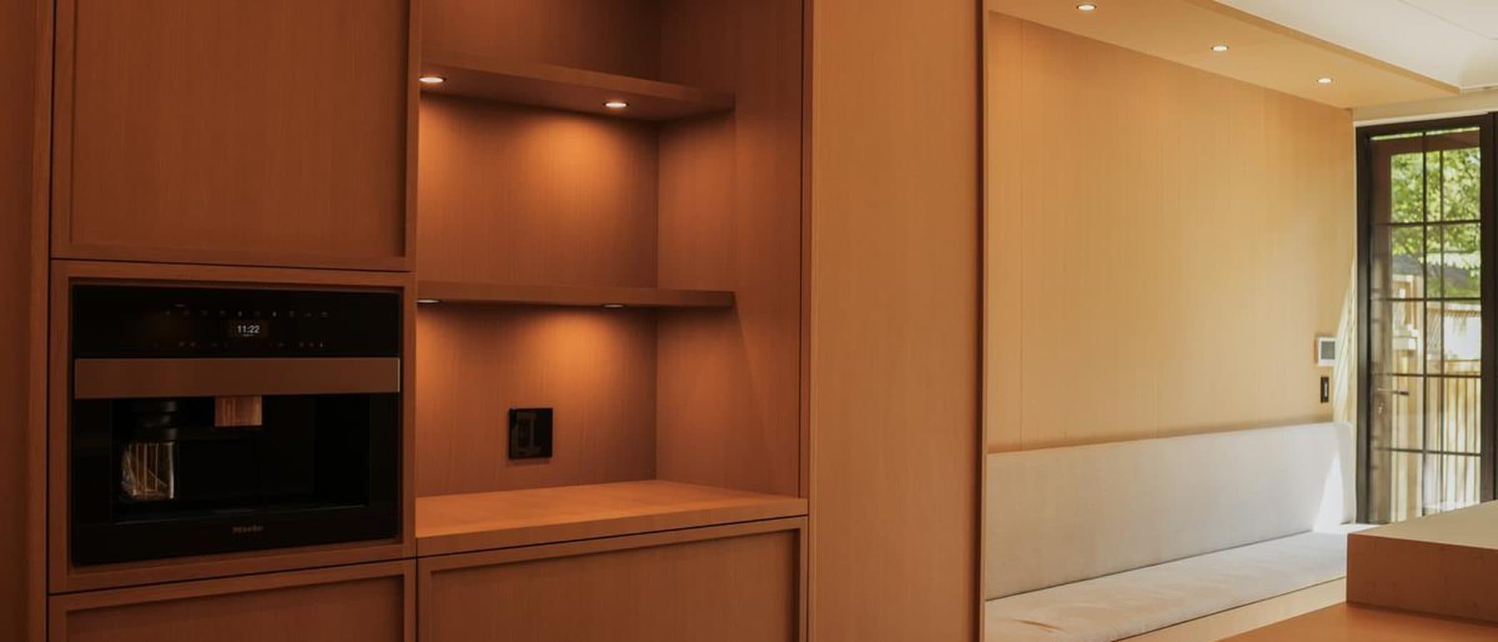 Built-in oak millwork wall with open shelving and an integrated coffee station