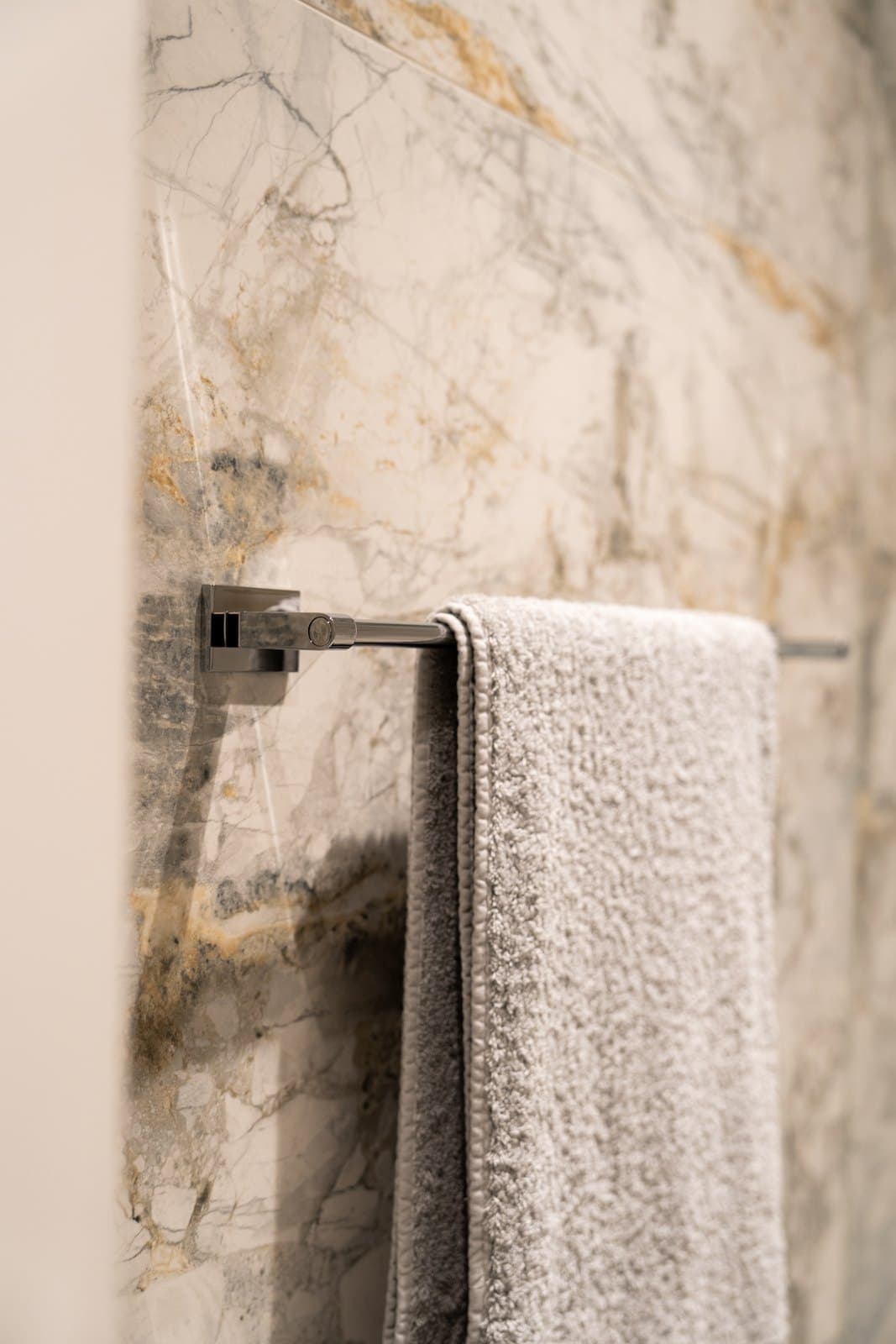 Book matched marble wall detail with a polished towel rail
