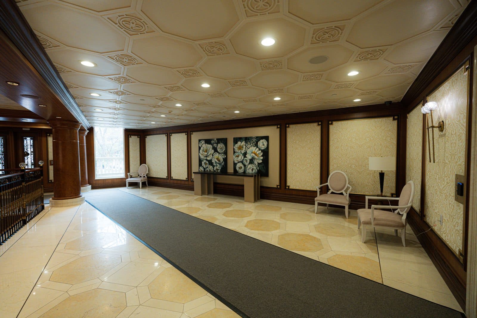 Lobby seating with a floral painting above a dark wood console