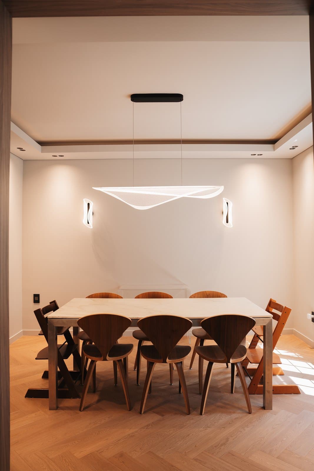 Dining room with a custom marble table under a sculptural winged pendant