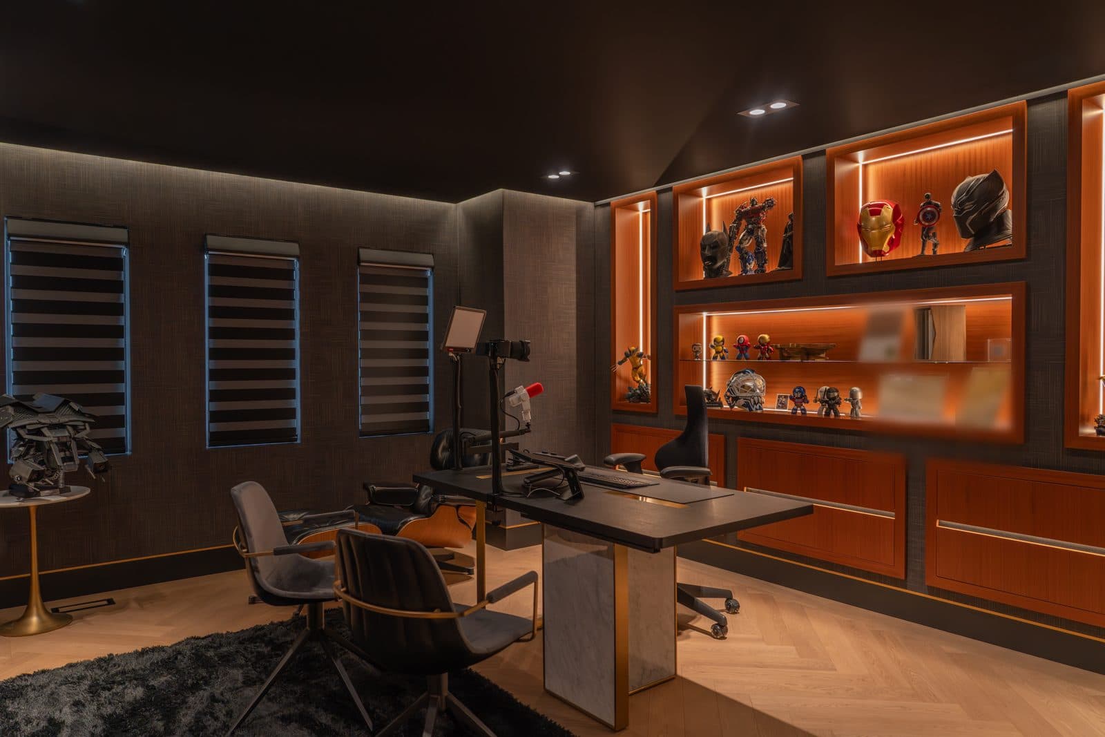 Home office in dark textured panels with backlit display millwork and a custom desk