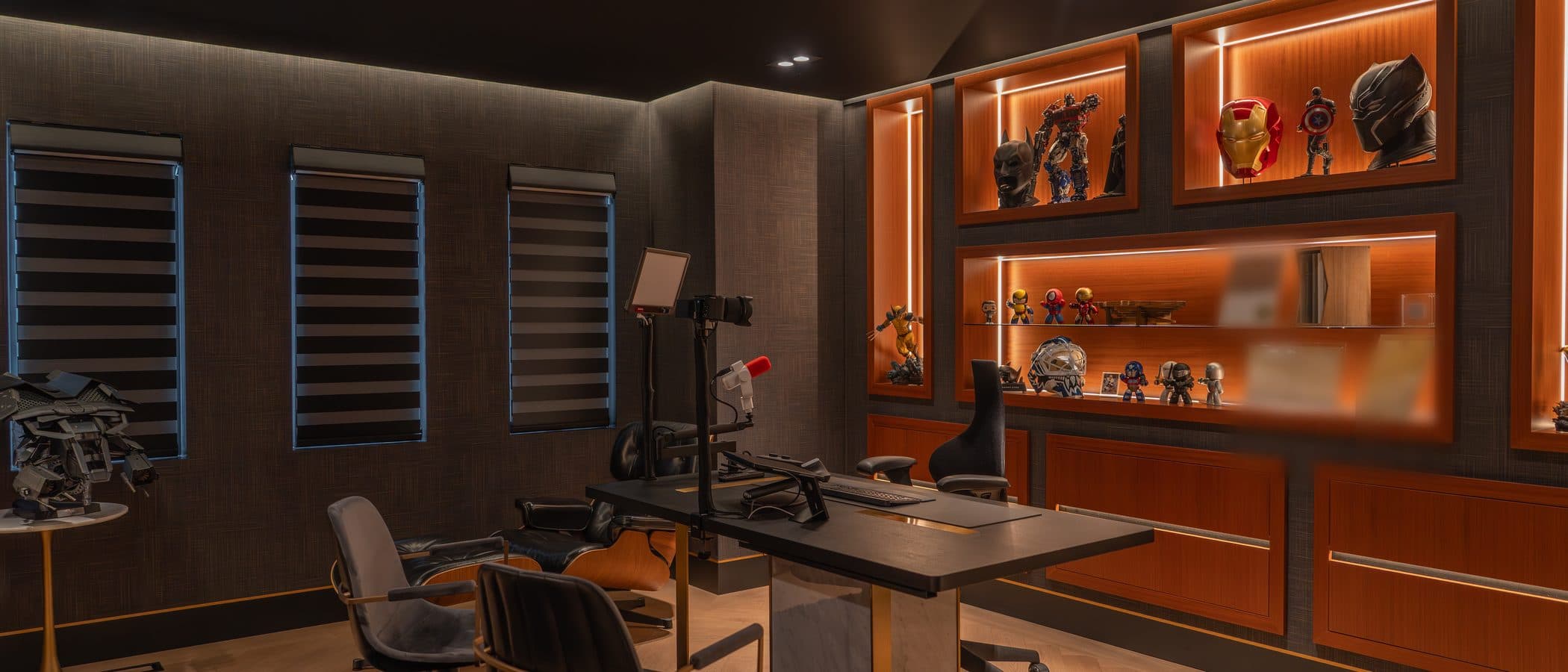Home office in dark textured panels with backlit display millwork and a custom desk