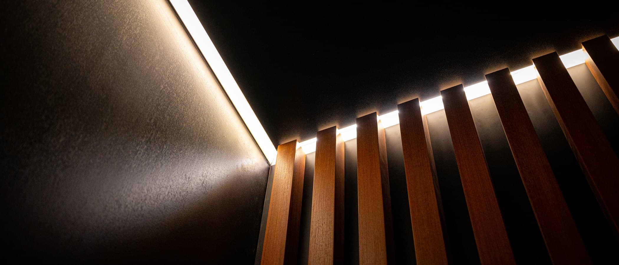 Backlit timber slat wall sweeping through the Leman showroom