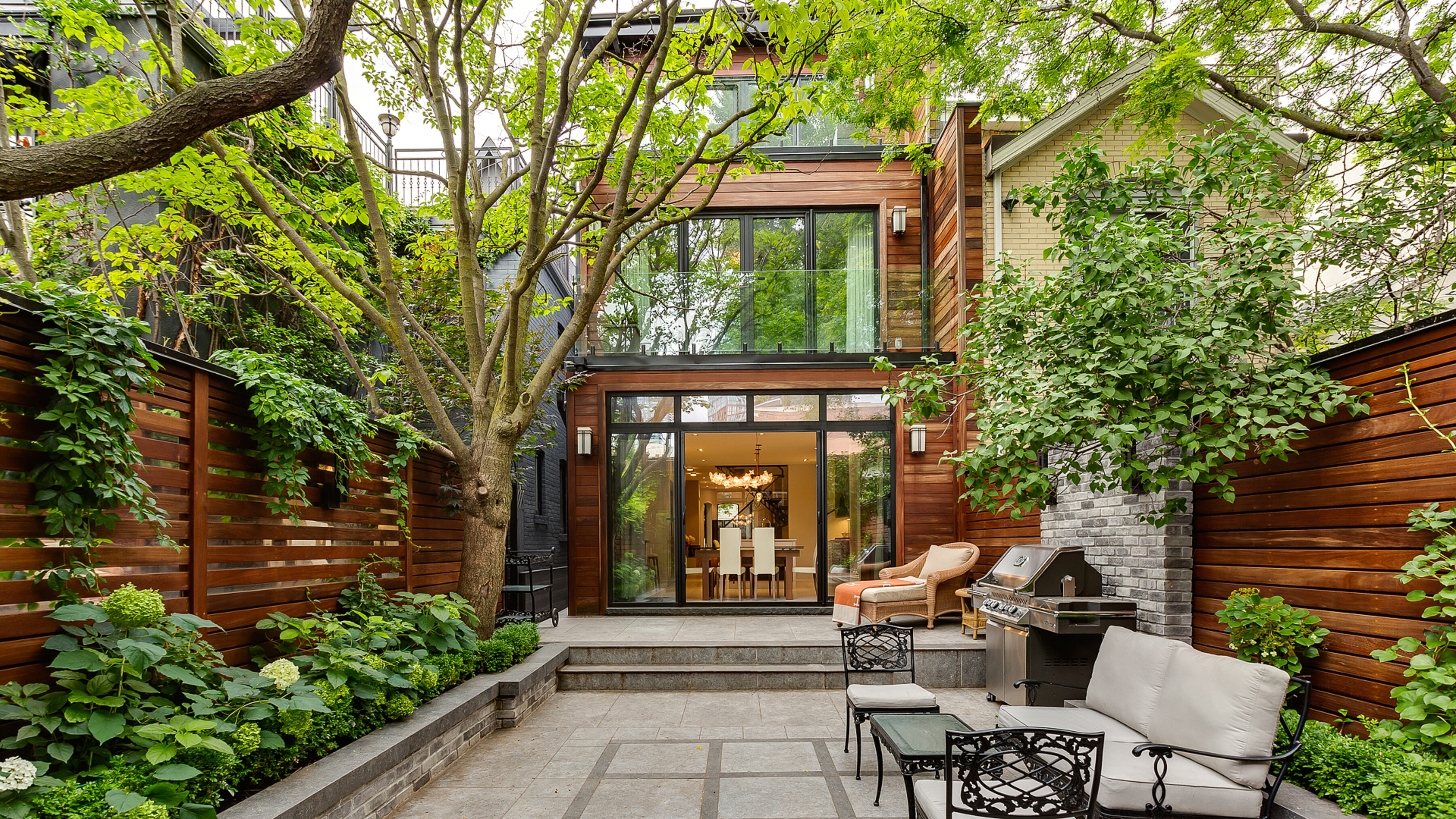 Rear cedar and glass addition rising above the garden terrace
