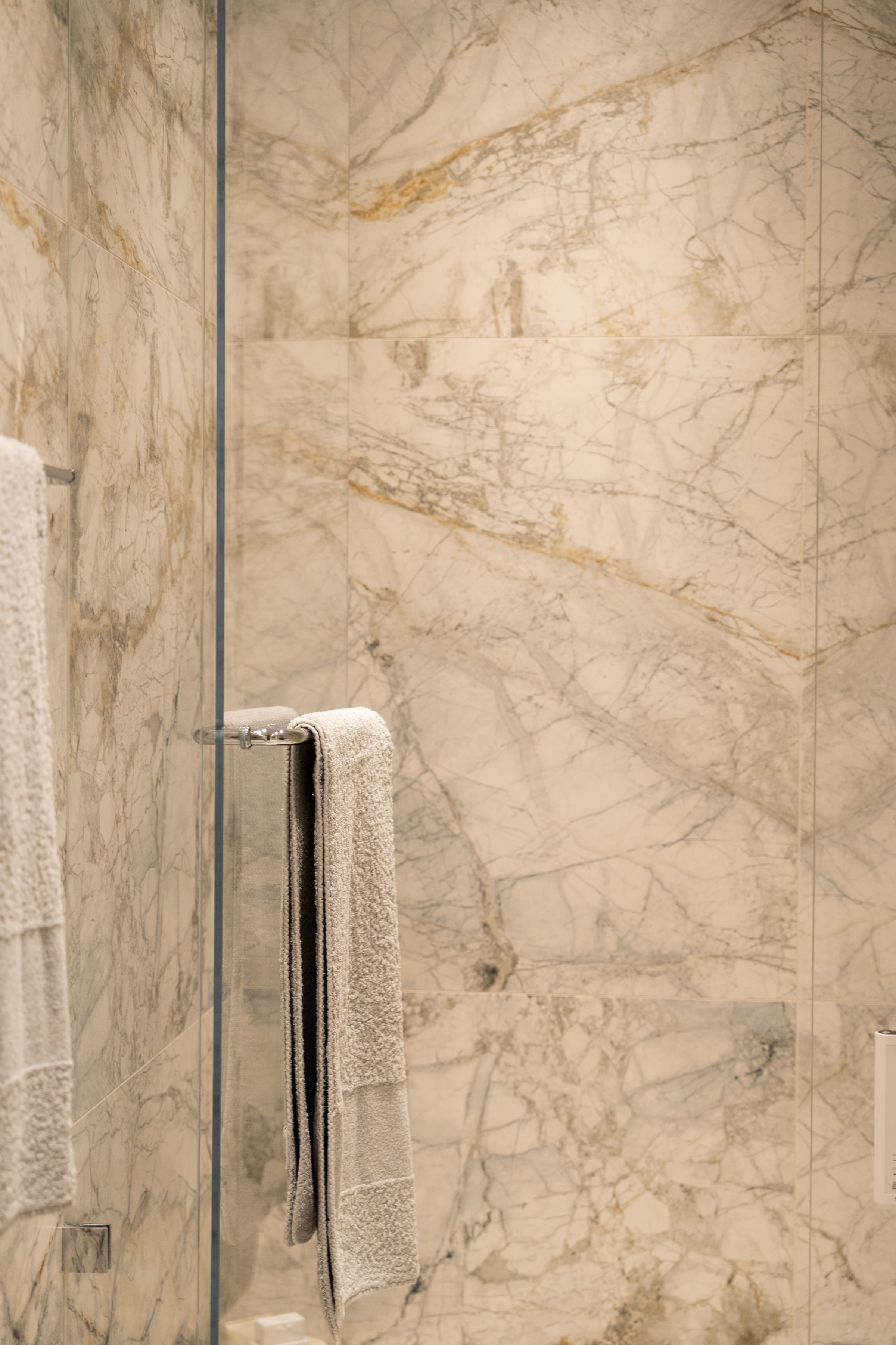 Shower wall wrapped in continuous veined marble