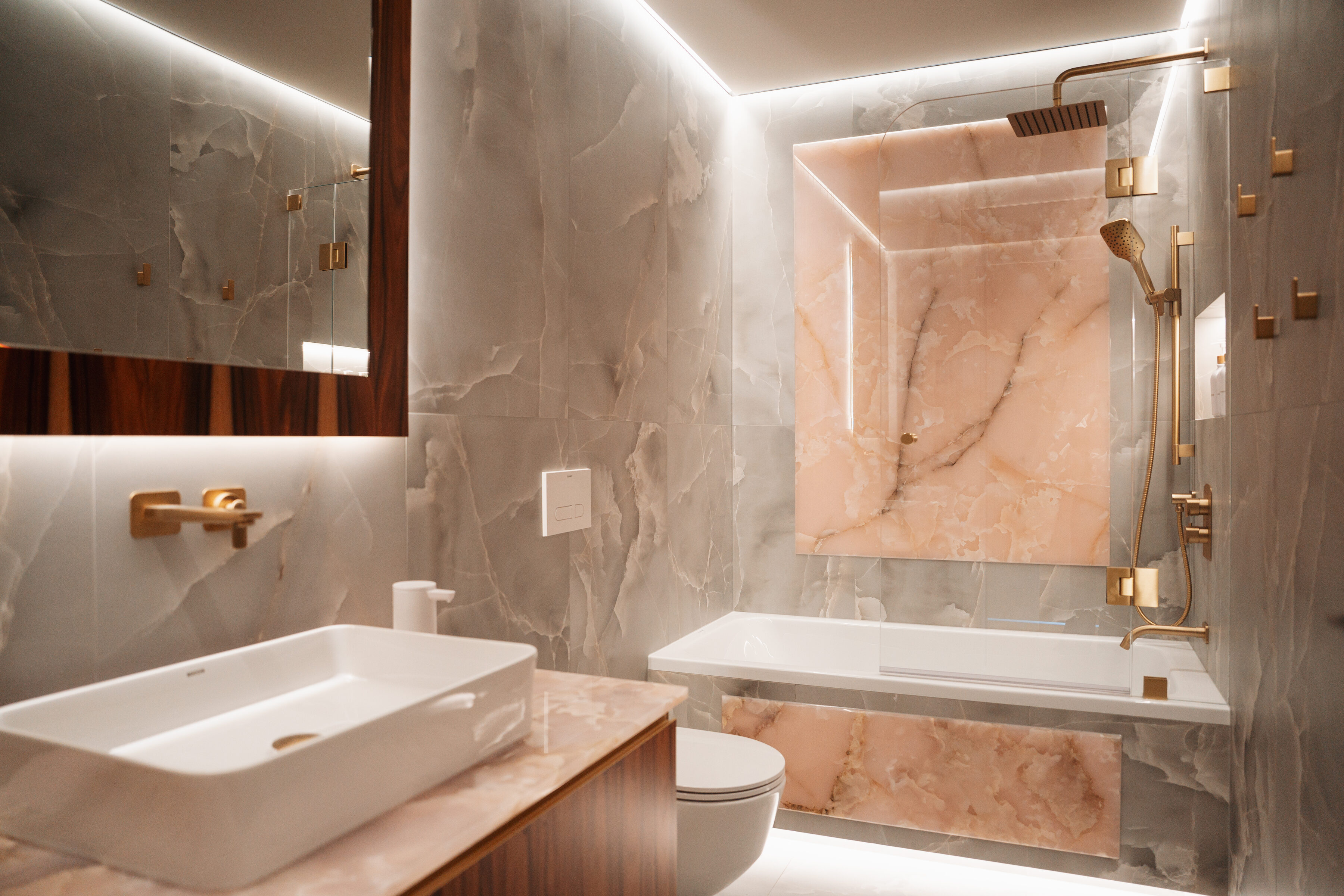 Illuminated onyx panel with brass fittings in the spa bathroom